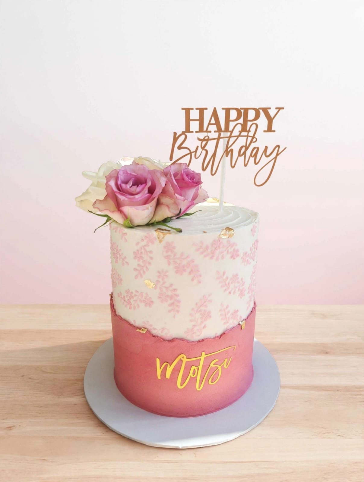 Pink ombré birthday cake with fresh roses and a gold script topper