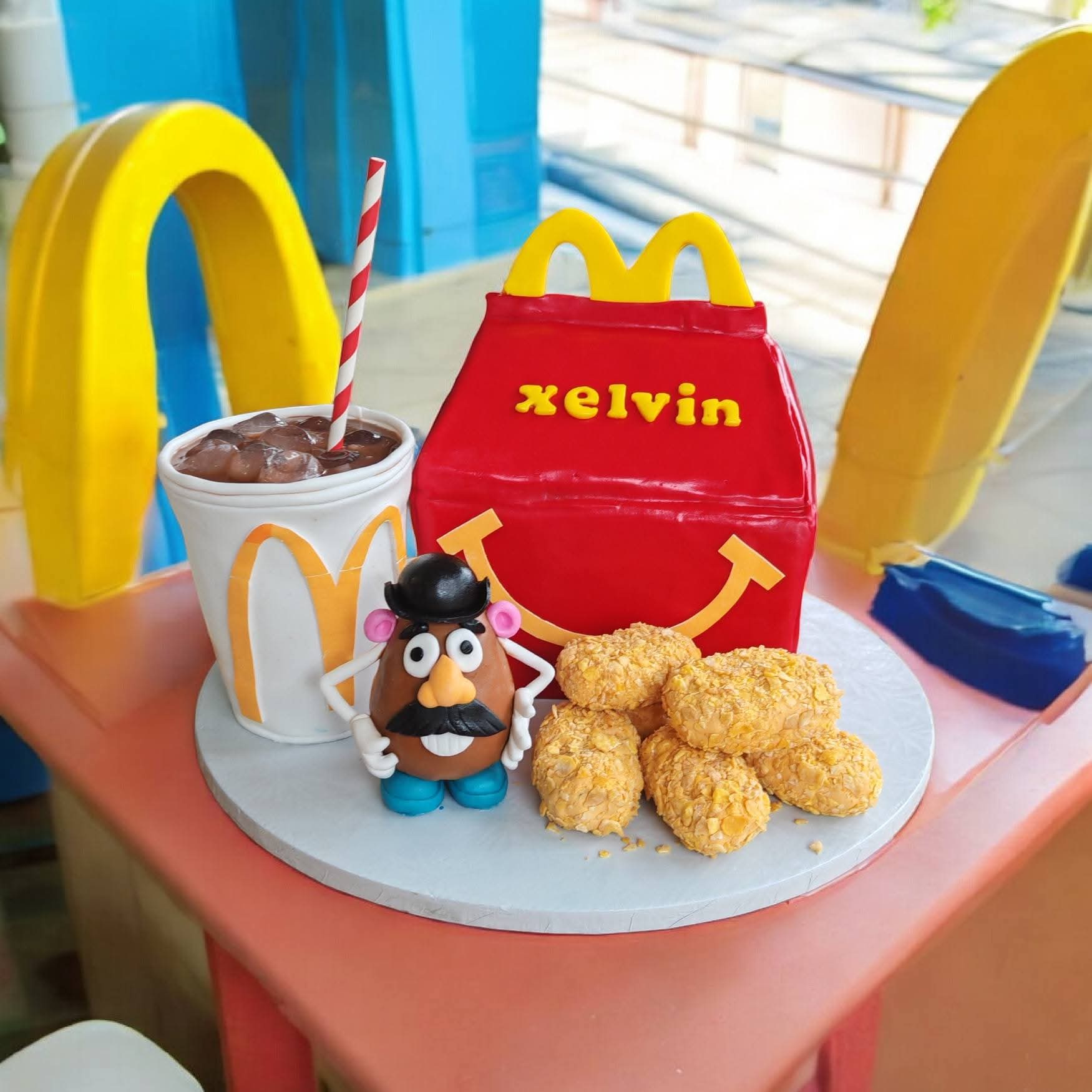 Sculpted McDonald's Happy Meal cake with a drink cup, nuggets and Mr Potato Head
