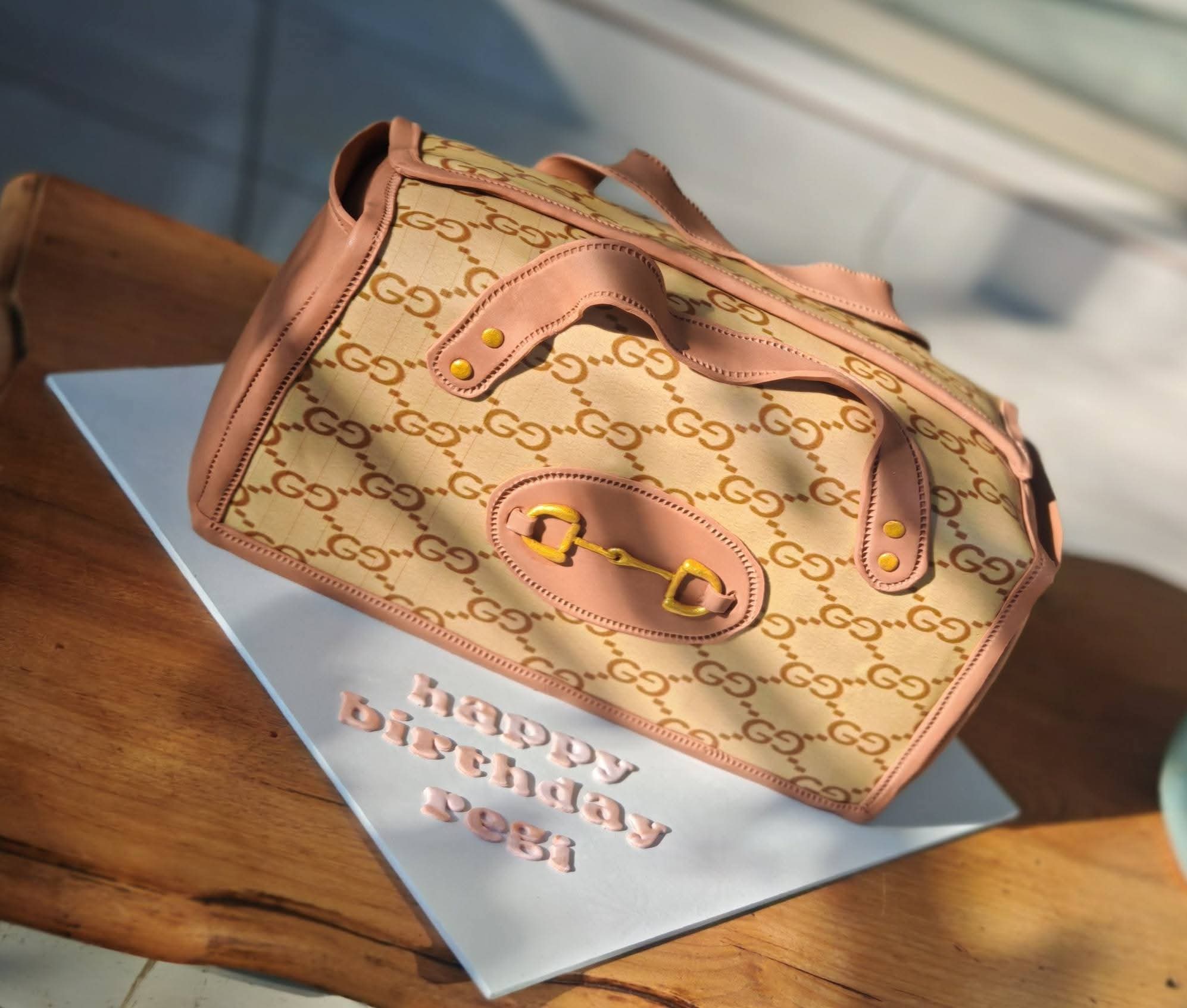 Sculpted designer handbag cake with hand-piped monogram print