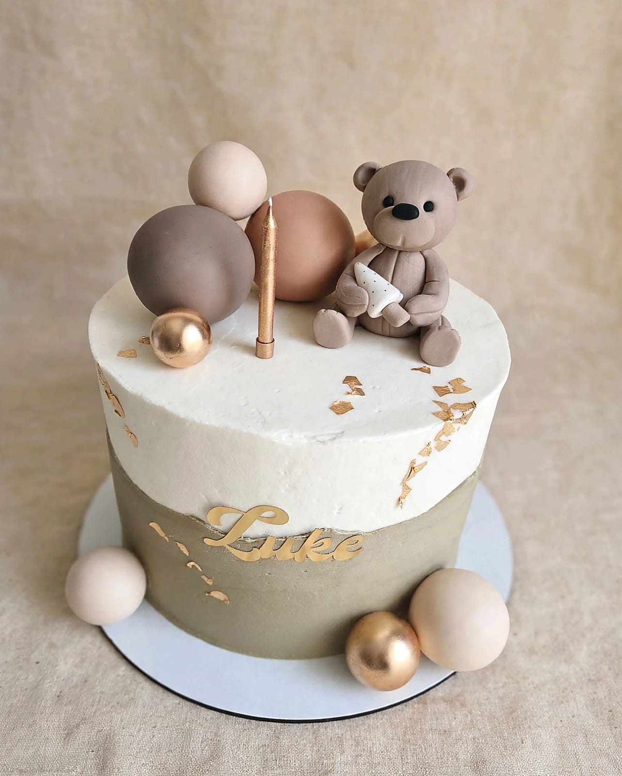 Cream and gold christening cake with a fondant teddy bear